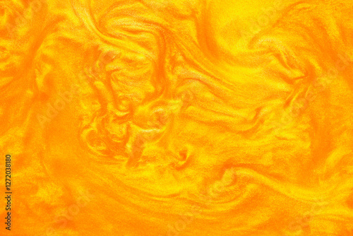 Shimmering gold abstract background. Liquid gold texture waves and swirls. Beautiful shiny yellow texture with glitter. Liquid gold metallic paint close-up.