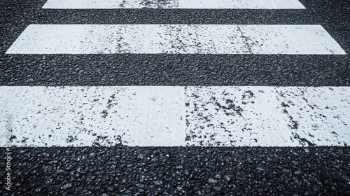 Close-up view of pedestrian crossing lines on urban asphalt in high contrast and texture photo