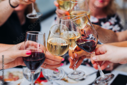 Fotografie Group of guests celebrate and raise glasses, toasting and cheering with alcohol