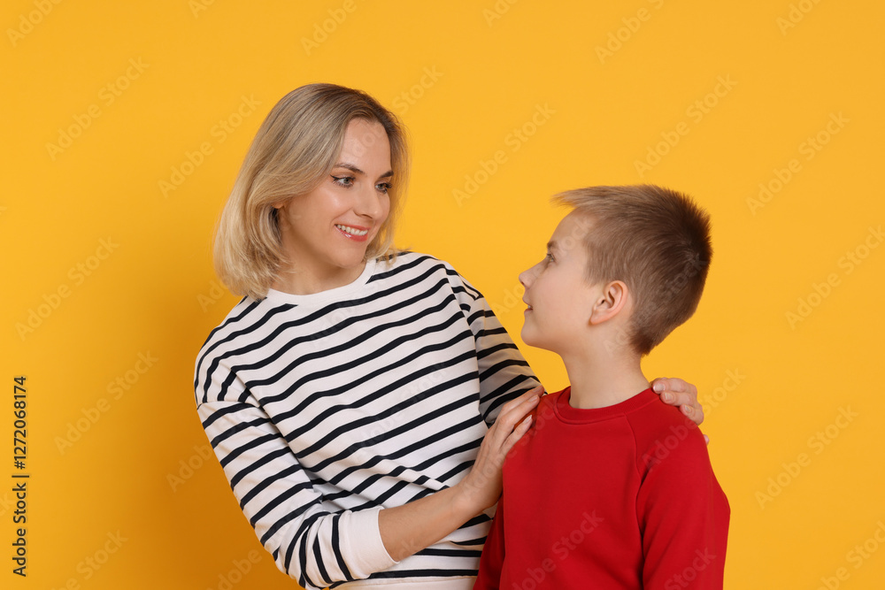 Happy mother and son on orange background Happy mother and son on orange background