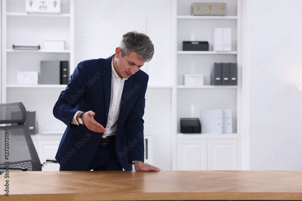 Man pointing at something on desk in office. Space for text Man pointing at something on desk in office. Space for text