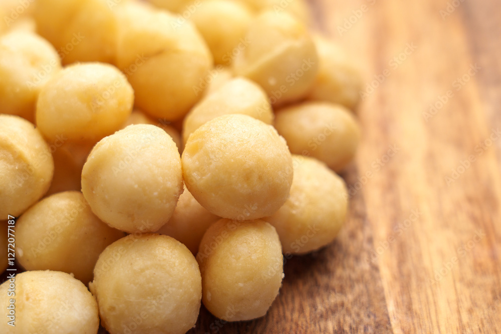 Macadamia nuts on wooden surface. Natural nutritious snack Macadamia nuts on wooden surface. Natural nutritious snack