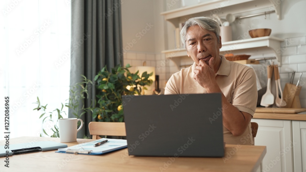 Stressful senior man looking at financial data and making decision. Elder business man working and using computer while planning digital marketing strategy and sitting at home. Problem. Myrmidon. Stressful senior man looking at financial data and making decision. Elder business man working and using computer while planning digital marketing strategy and sitting at home. Problem. Myrmidon.
