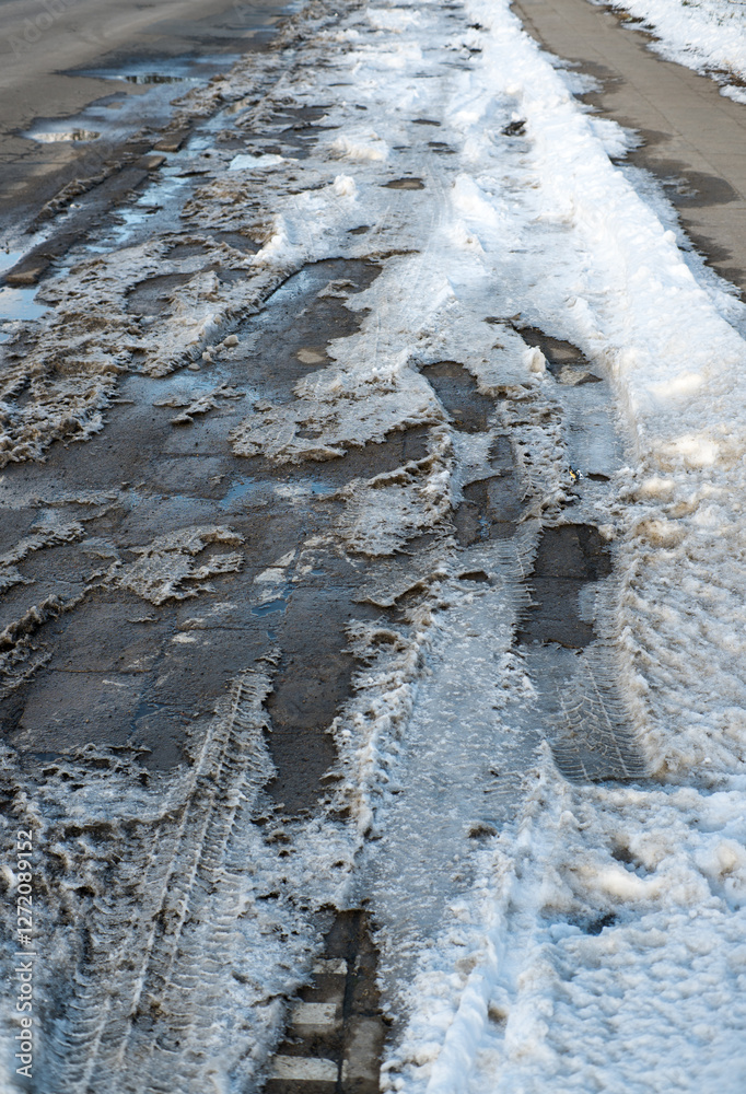 Snow and mud on the side of the road and sidewalk