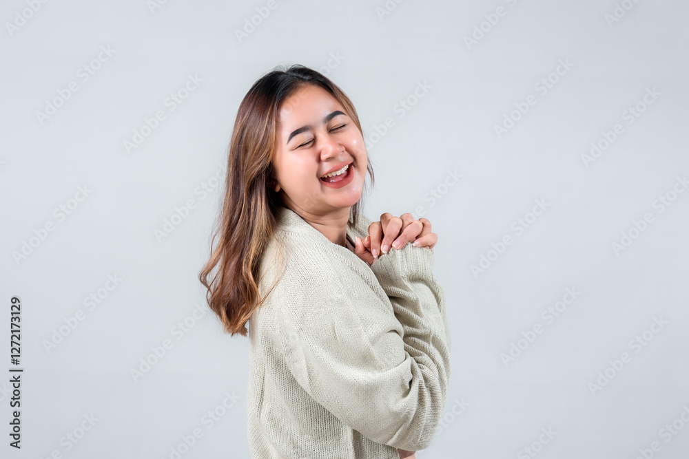 A joyful young woman smiles brightly, showcasing her happiness in a cozy sweater against a neutral background, embodying warmth and positivity. A joyful young woman smiles brightly, showcasing her happiness in a cozy sweater against a neutral background, embodying warmth and positivity.