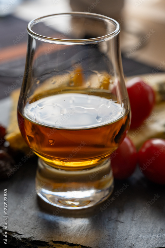 Whiskey and cheese pairing, tasting whisky glass and plate with sliced blue stilton and blue shropshire cheeses, Great Britain food and drink Whiskey and cheese pairing, tasting whisky glass and plate with sliced blue stilton and blue shropshire cheeses, Great Britain food and drink