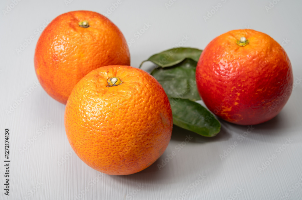 Sicilian sweet juicy yellow and red blood oranges with green leaves close-up Sicilian sweet juicy yellow and red blood oranges with green leaves close-up