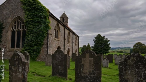 Old church surrounded by gravestones in overcast landscape