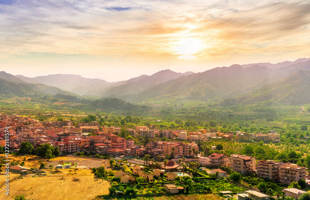 Obraz premium scenic panorama of italian town during sunset with amazing view from above to nice city with picturesque mountain valley landscape and cloudy sky on backdrop