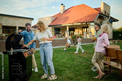 фотографія Happy family having barbecue party in backyard,