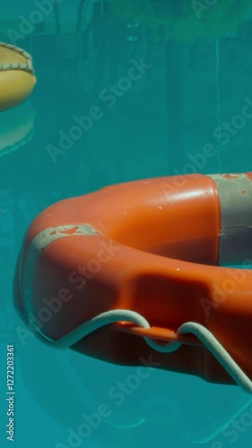 Lifesavers Floating On A Swimming Pool On A Sunny Day At A Hotel
