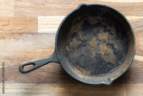 Old rusty cast iron frying pan background. On a wooden chopping cutting board.