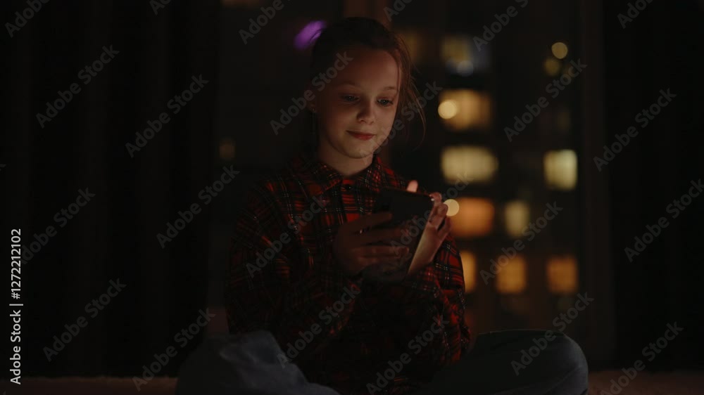 Portrait of preteen girl browsing smartphone screen, nighttime cityscape reflecting on window, soft digital glow illuminating pensive facial expression, enjoying mobile apps, games, social media. Portrait of preteen girl browsing smartphone screen, nighttime cityscape reflecting on window, soft digital glow illuminating pensive facial expression, enjoying mobile apps, games, social media.