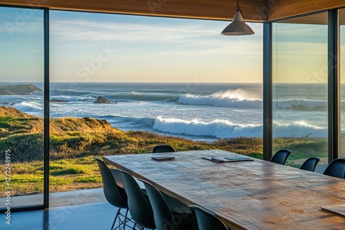 A modern meeting room with a breathtaking ocean view, featuring large glass windows, a wooden table, and crashing waves in the background
