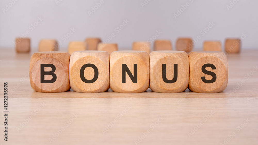 the text BONUS is written on wooden blocks on a brown background the text BONUS is written on wooden blocks on a brown background