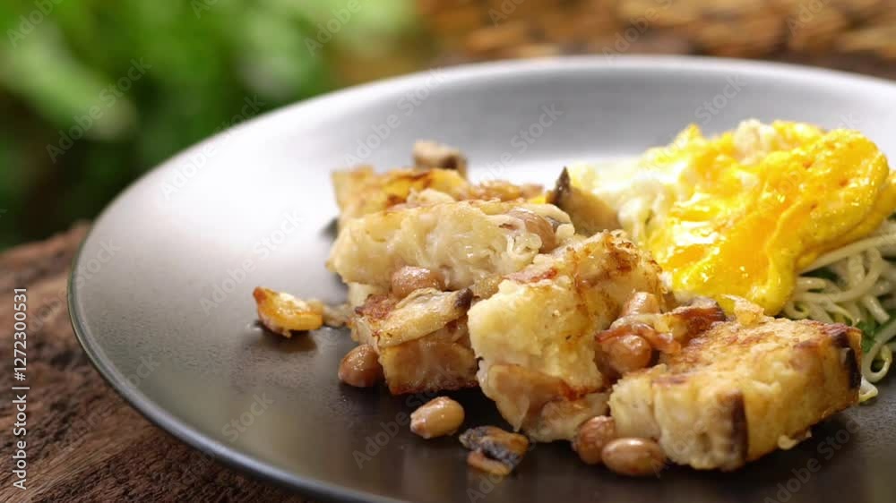 Fried Turnip Cake on wooden table. Traditional Chinese food. Fried Carrot Cake or local call name Fried Turnip Cake on wooden table. Traditional Chinese food. Fried Carrot Cake or local call name