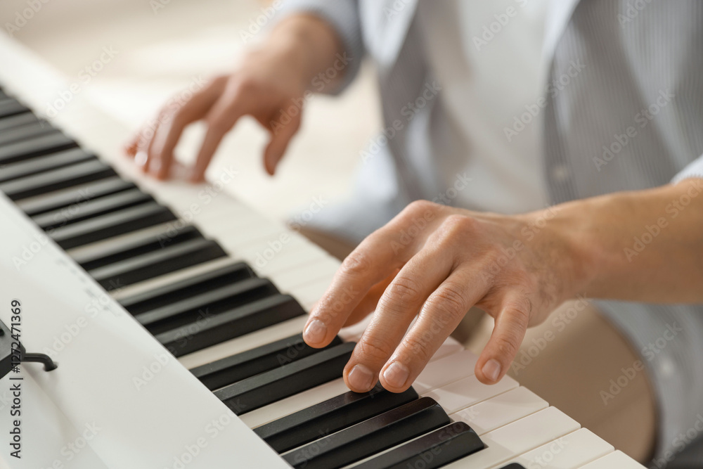 Fototapeta premium Man playing synthesizer indoors, closeup. Electronic musical instrument