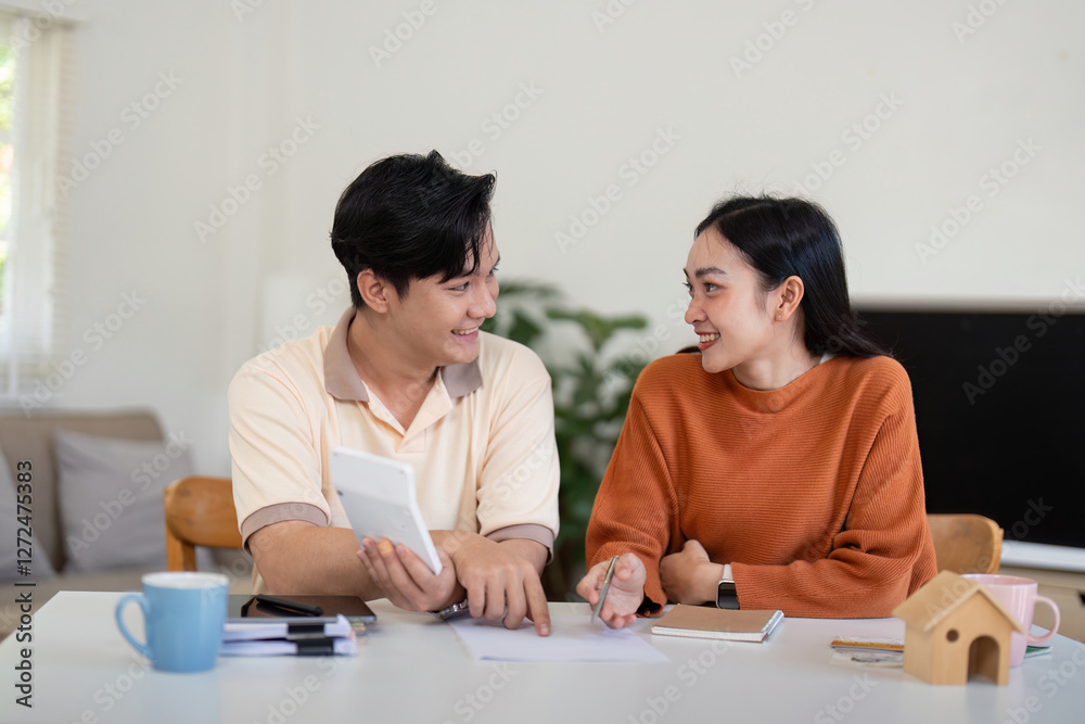 Happy couple discussing finances and income calculations with smiles at home. Happy couple discussing finances and income calculations with smiles at home.