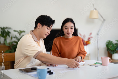 Couple engaged in financial planning and budgeting at home, discussing bills and strategies. photo