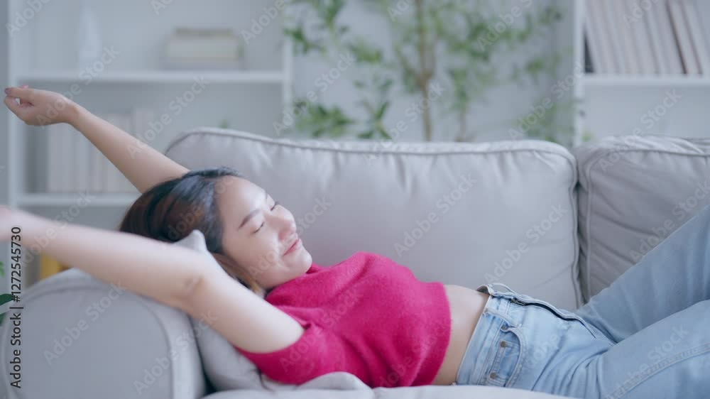 Asian woman resting at home on couch, feeling exhausted after work, lacking energy, or overworked, too tired, and lacking motivation Asian woman resting at home on couch, feeling exhausted after work, lacking energy, or overworked, too tired, and lacking motivation