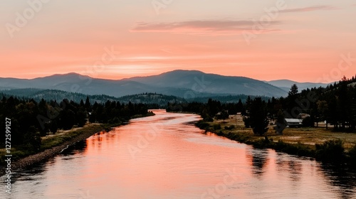 Serene river reflecting sunrise over mountains