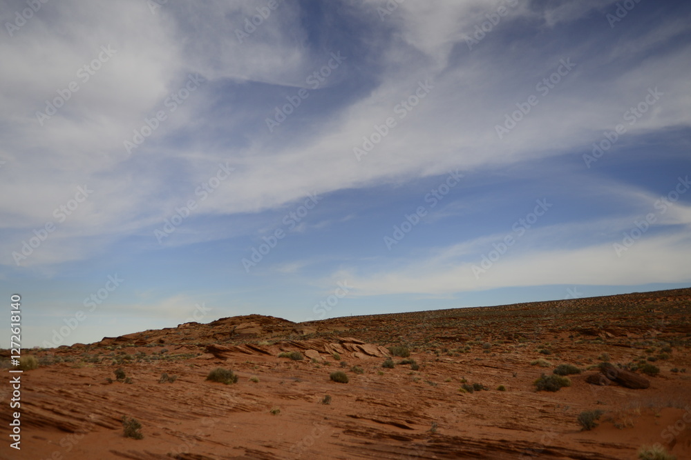 Fototapeta premium Rugged desert terrain under soft cloud patterns in the expansive Antelope Canyon area