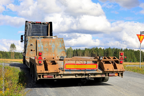 Heavy Truck Pulling Low Loader Trailer Makes Right Turn, Rear View.