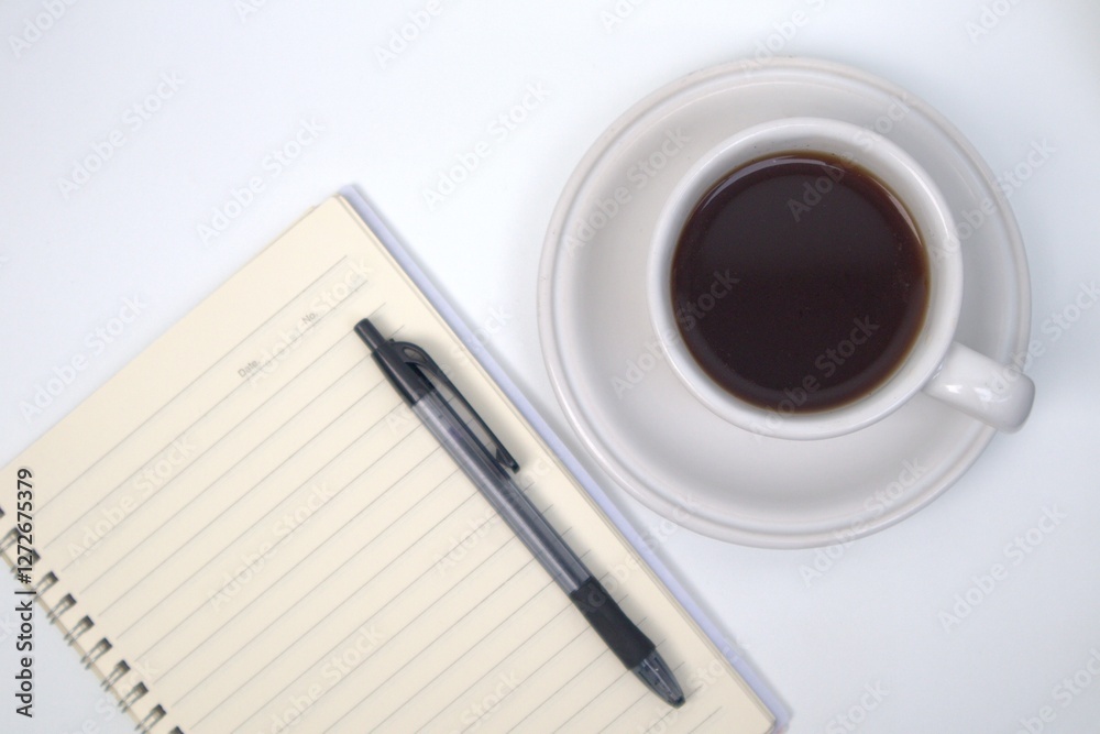 Cup of coffee, notebook and pen on white table Cup of coffee, notebook and pen on white table