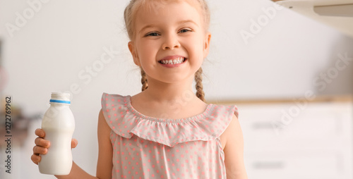 Foto Happy little girl with bottle of yogurt at home