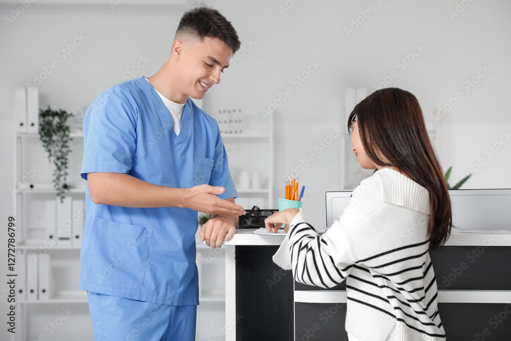 Medical intern working with female patient at reception in clinic Medical intern working with female patient at reception in clinic