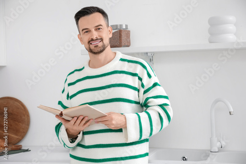 Handsome man reading book i...