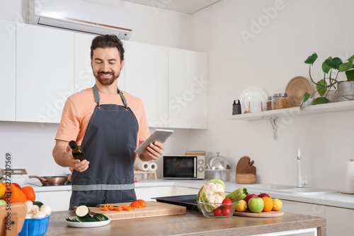 Smiling man in apron cookin...