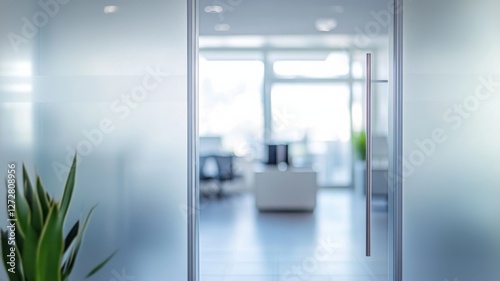 Modern minimalist glass door leading to a bright office space with soft natural light and simple furnishings
