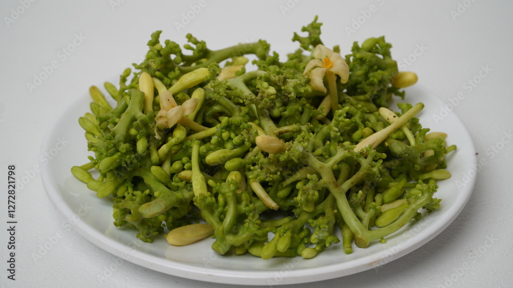 A collection of raw papaya flowers placed on a white plate with a white base and background (isolated white). A collection of raw papaya flowers placed on a white plate with a white base and background (isolated white).