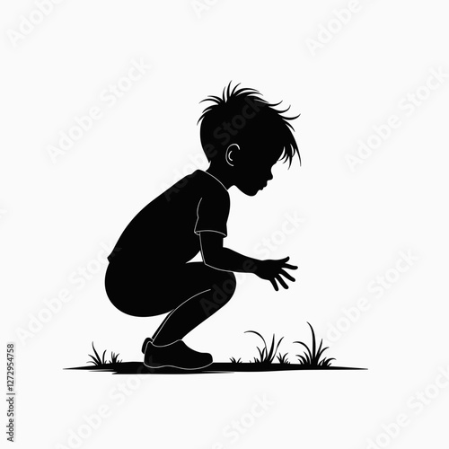 Silhouette of a boy squatting and observing grass