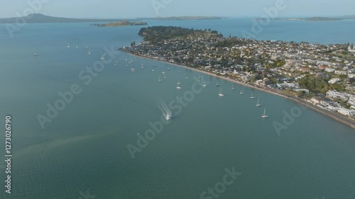 Aerial view of boats in a bay, with a residential area along the shore. Sunny day, calm waters. BUCKLANDS BEACH, AUCKLAND, NZ photo