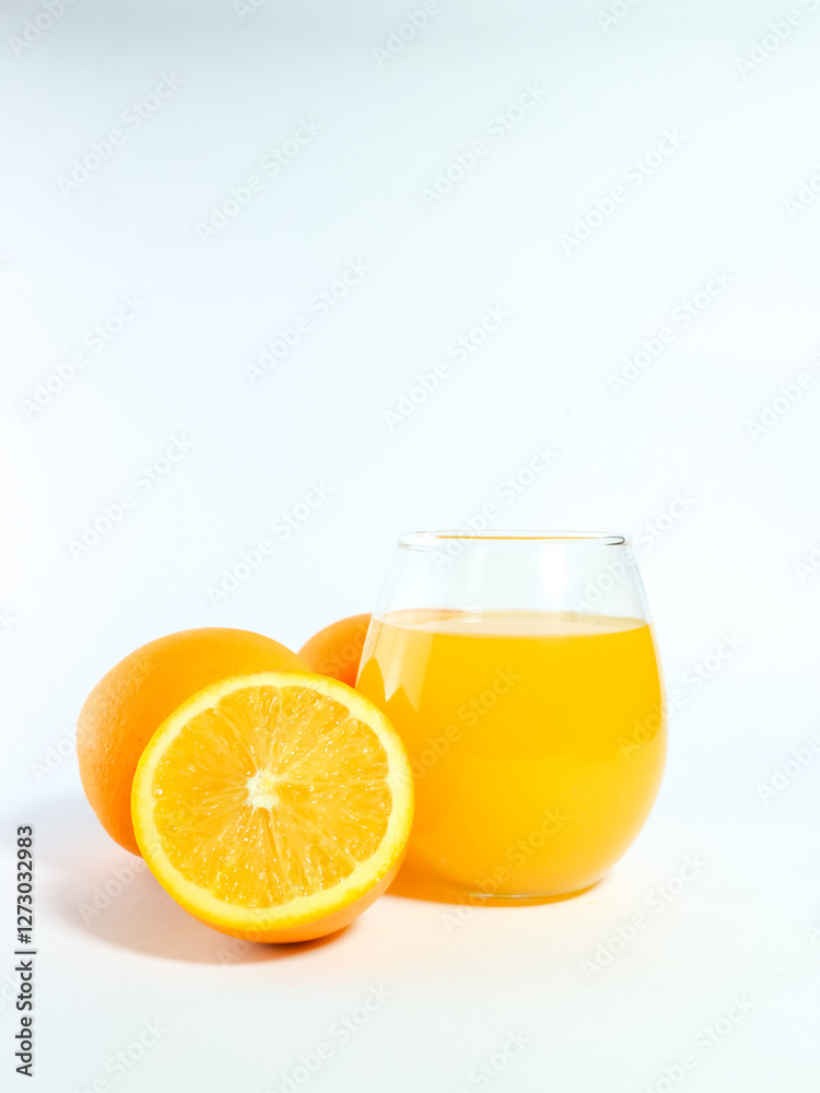 Fresh orange juice in a glass with whole and sliced oranges isolated on a white background Fresh orange juice in a glass with whole and sliced oranges isolated on a white background