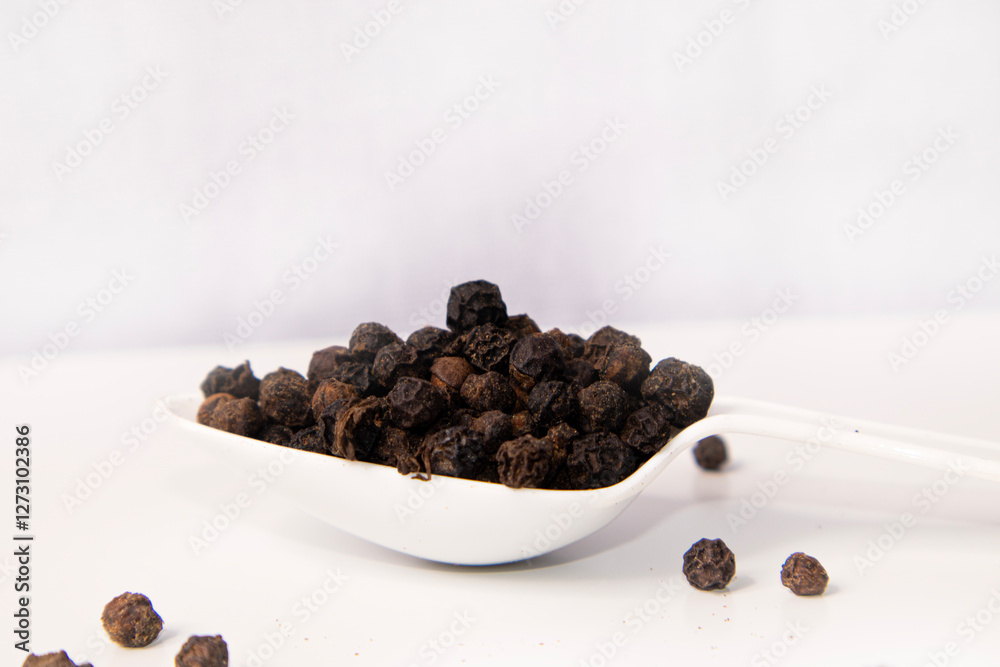 Black pepper seeds spoon isolated on white Black pepper seeds spoon isolated on white