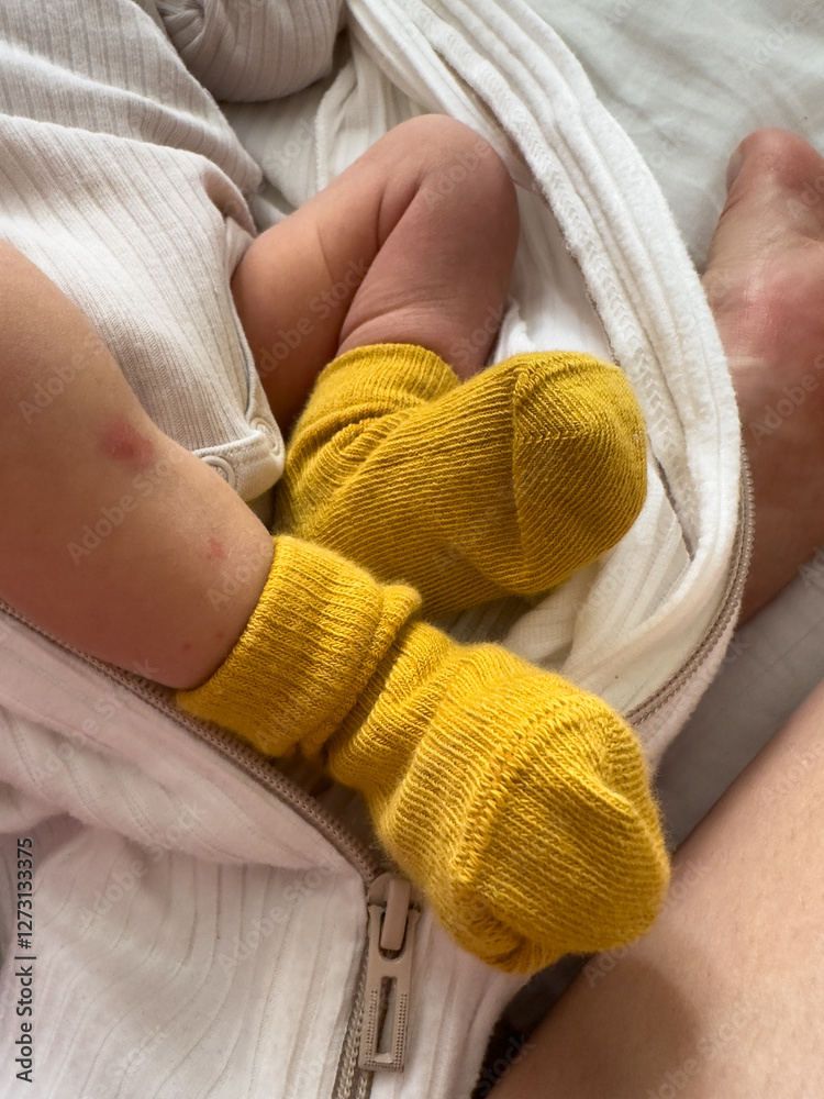 Baby in Yellow Socks Wrapped in White Blanket