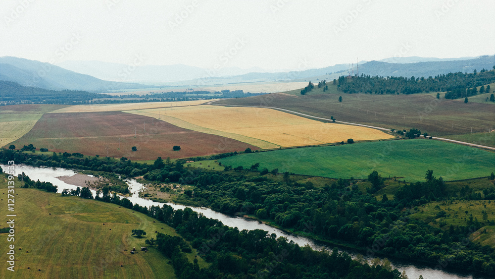 Obraz premium A tranquil river winding through rocky cliffs and dense forests, creating a breathtaking natural landscape captured in aerial drone footage