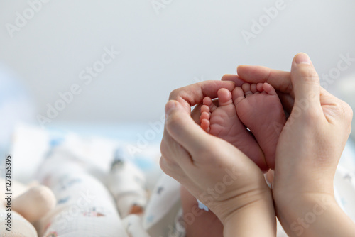 A baby's feet are being held by a parent