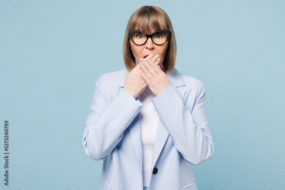 Blonde sad scared shocked surprised employee business woman 50s wear classic suit glasses formal clothes cover mouth with hands isolated on plain pastel light blue background. Lifestyle work concept. Blonde sad scared shocked surprised employee business woman 50s wear classic suit glasses formal clothes cover mouth with hands isolated on plain pastel light blue background. Lifestyle work concept.
