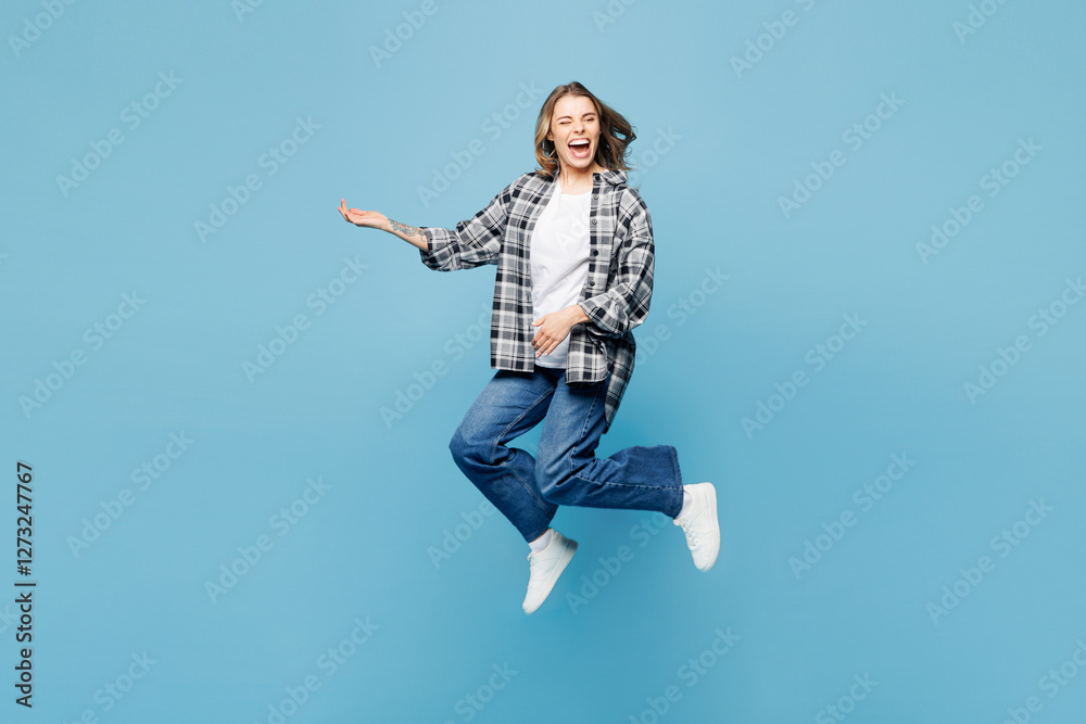 Full body young excited woman she wears checkered grey shirt casual clothes jump high play imaginary air guitar isolated on plain pastel light blue cyan background studio portrait. Lifestyle concept. Full body young excited woman she wears checkered grey shirt casual clothes jump high play imaginary air guitar isolated on plain pastel light blue cyan background studio portrait. Lifestyle concept.