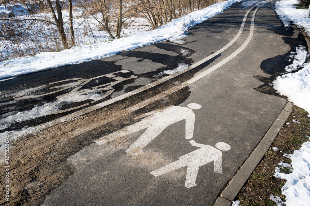 Road markings with separate lanes for pedestrians and bicycles. Winter conditions.