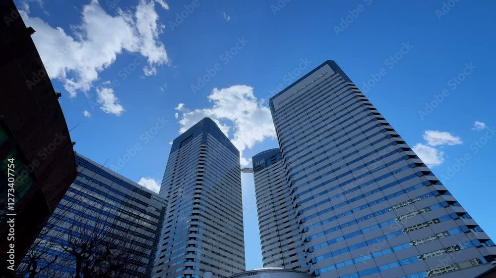 Modern skyscrapers in Harumi, Tokyo, under a bright blue sky with scattered clouds Modern skyscrapers in Harumi, Tokyo, under a bright blue sky with scattered clouds