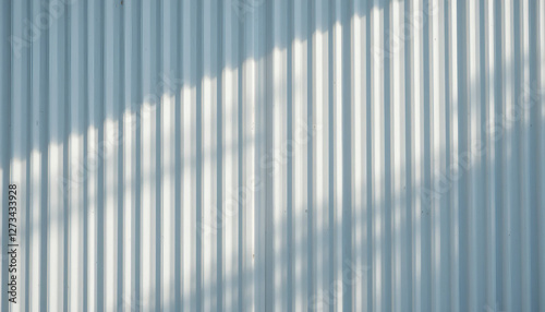 White corrugated metal siding with subtle shadows and reflections, creating a sleek and modern architectural background.