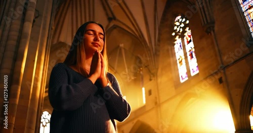 A young woman prays in a church