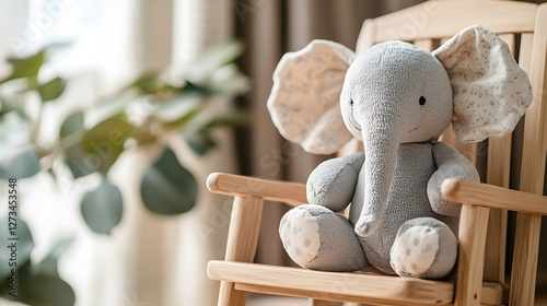 Stuffed elephant sitting in a wooden toy rocking chair with vintage nursery theme photo