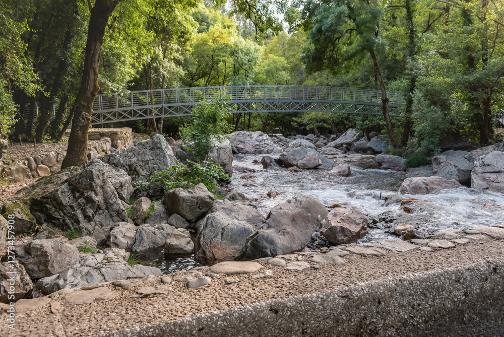 Landscape at Fragas de São Simão river beach with motion of the water of the Alge stream between rocks and with a bridge, PORTUGAL Landscape at Fragas de São Simão river beach with motion of the water of the Alge stream between rocks and with a bridge, PORTUGAL