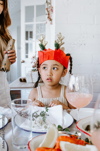 Young Asian girl seated on the table glancing sideways photo